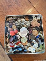 Metal tin full of assorted buttons