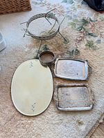 Silver-plated lattice stand, oval tray, two rectangular silver trays and cylindrical holder on carpet