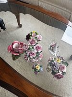 Five china floral pieces on glass table