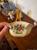 Close view of Noritake porcelain handled basket showing floral design and gold handle