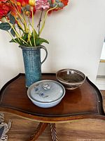 All three pottery pieces on table: pitcher vase, lidded casserole, bowl