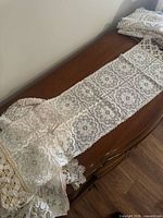 Long rectangular white crochet runner with square medallions