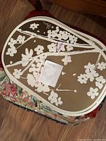 Stack of assorted placemats; top piece tan/white floral silhouette