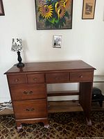 Front view of wood desk showing four drawers and open knee space