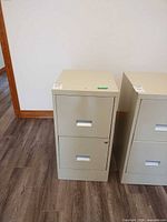 Front view of the beige two-drawer metal filing cabinet