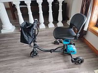 Side view of scooter showing overall condition, seat, battery housing, three wheels