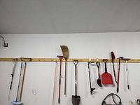 Overall wall view showing multiple long-handled garden tools