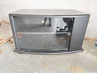 Front view of black laminate TV stand with glass door, shelf visible