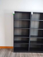 Front view of black engineered wood bookcase with five shelf spaces