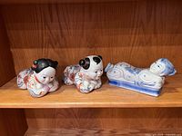All three ceramic figurines displayed on shelf