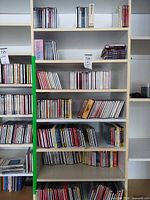 Full bookshelf with multiple shelves of classical CDs, showing quantity and jewel case condition