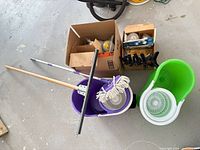 Overall lot showing spin mop buckets, mop head, squeegee, cartons, clamps