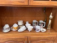 Full shelf view showing all porcelain, steins, bottle and vase