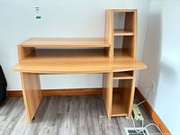 Front view of light oak laminate computer desk with upper shelf and side cubby storage