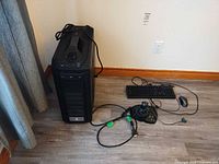 Full view of desktop tower, keyboard, mouse and flight joystick on floor