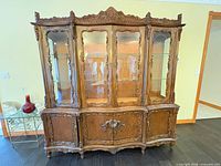 Front view of china cabinet showing glass doors and carved details