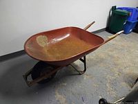 Side view of Garant wheelbarrow showing metal tray, wood handles, front wheel