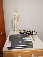 Ultrasound unit closed on dresser with probe, cables and acupuncture mannequin