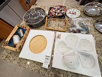 Overview of lot showing brown crudité dish, charcuterie set box, Disney plates, Mirro cookie press, cookie cutters, glass set