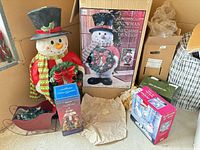 Group shot showing snowman, metal sleigh with lights and packaging boxes