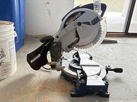 Left side view of Mastercraft miter saw showing blade, guard, dust bag, and base