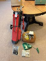 Full lot view showing red bag, basket of balls, putting aid, packaged items