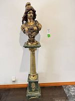 Entire bust on pedestal against wall