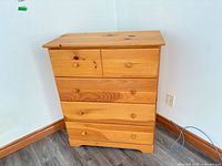 Front view of five-drawer knotty pine dresser