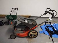 Left side profile of mower showing deck, wheels, handle, and detached bag