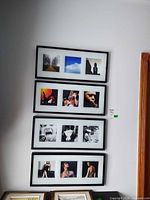 Four stacked black multi-photo frames on wall