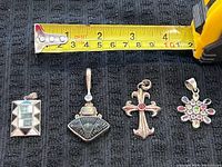 All four pendants beside tape for scale