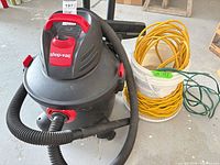 Shop-Vac vacuum with hose and yellow extension cord