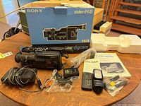 Full kit laid out showing camcorder, box, flash, remote, charger, cables, manual