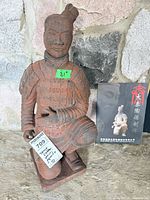 Full view of kneeling terracotta warrior statue with lot tag and informational booklet