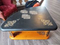 Top view showing black surface with gold stenciling and triangular rounded shape