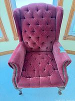 Front view of burgundy velvet tufted wingback chair