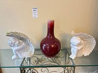 Full lot showing vase flanked by angel figurines on glass shelf