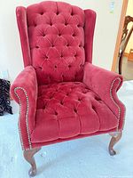front angled view of tufted burgundy wingback chair