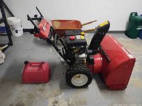 Side view of Yard Machines snow blower and gas can