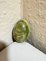 Front view of polished green onyx egg showing green surface