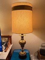 Full view of brass table lamp with shade