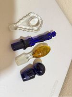 Overview of four glass stoppers showing colors and shapes