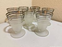 All seven frosted liqueur glasses side angle view