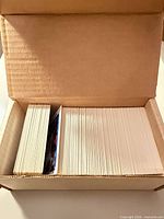 Top view of stacked basketball cards inside open cardboard storage box