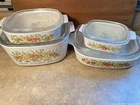 All four casseroles stacked with lids showing pattern and sizes