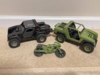 Black and green jeeps plus green motorcycle