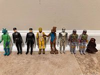 All nine figures lined up against wall