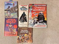 Five Star Wars books and comic spread on carpet