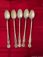 Front view of 5 matching silver-plated spoons