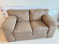 Front view of brown nylon loveseat showing overall design and cushions